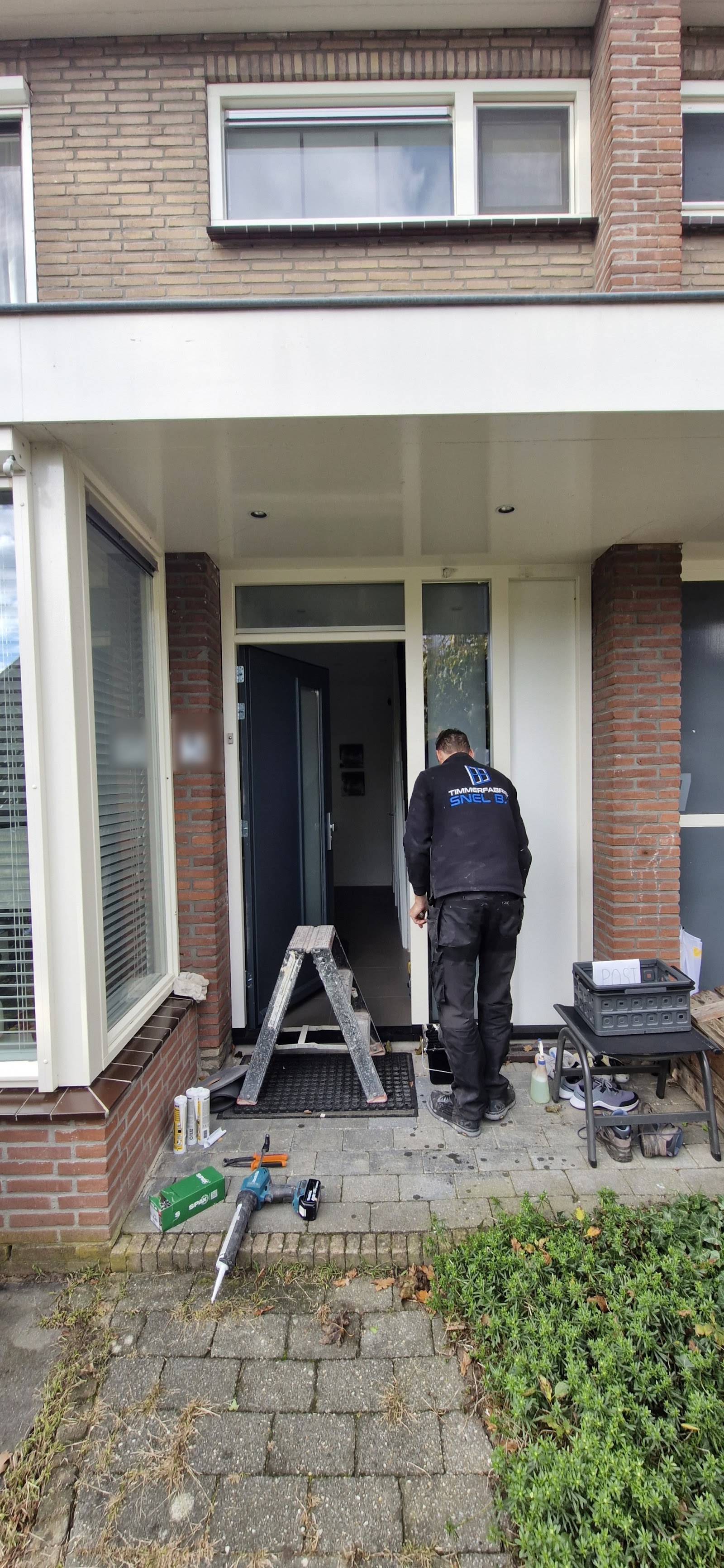 Monteur van Snel plaatst een voordeurkozijn met zijlicht